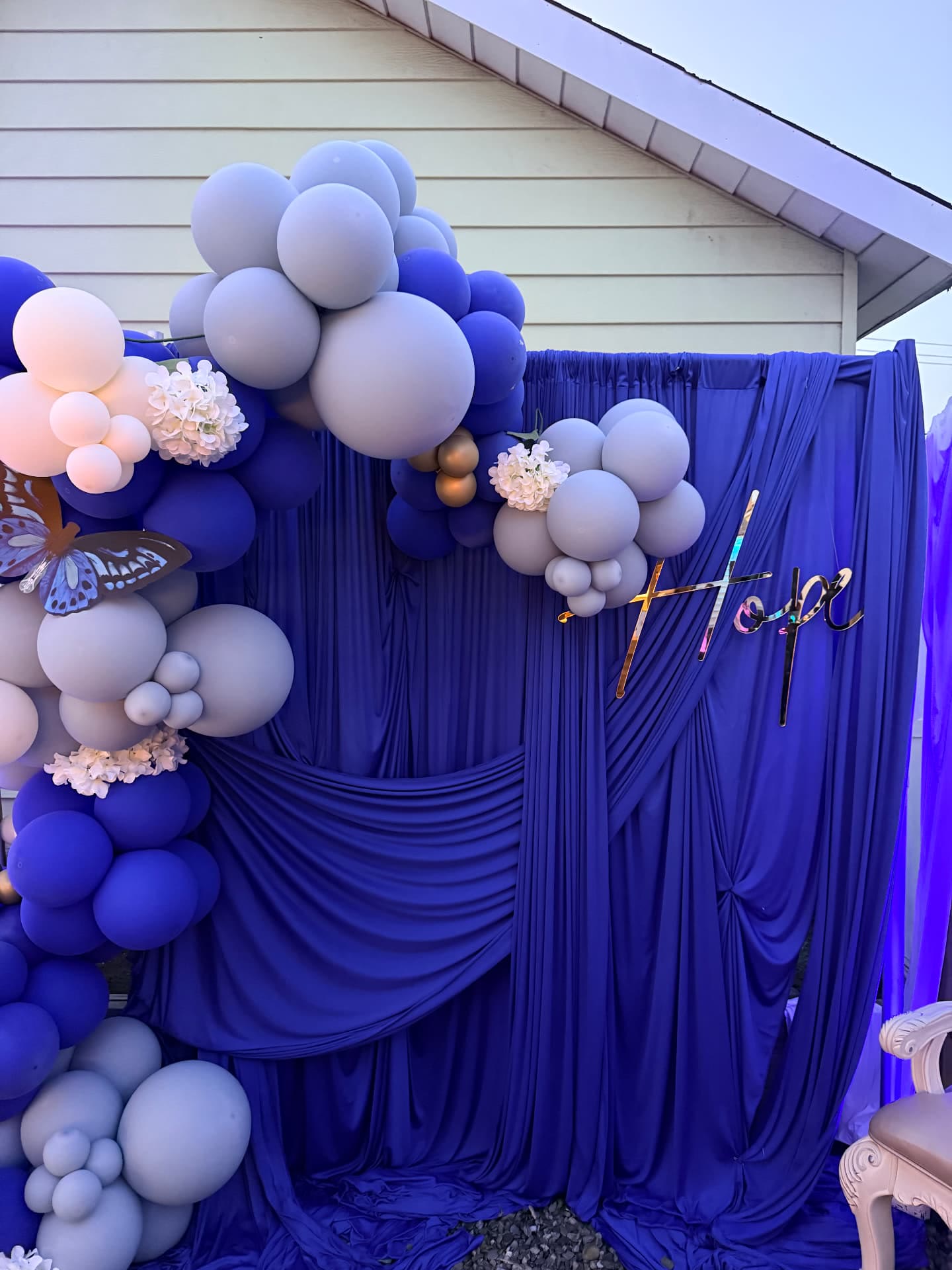 Balloon and draping focal installation with custom signage at a 100-plus guest milestone celebration